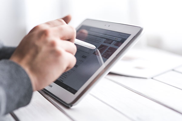 A man using a stylus on his tablet